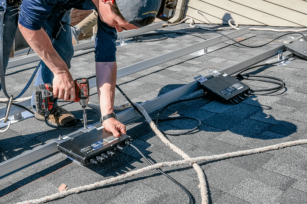 Instalador instalando micro inversor solar YC600 APsystems no telhado